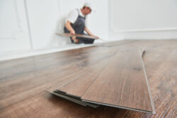 Worker,Laying,Vinyl,Floor,Covering,At,Home,Renovation